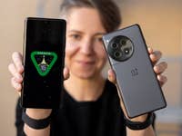 Eine Person hält zwei OnePlus-Smartphones, eines zeigt 'ANDROID 15' auf dem Bildschirm.