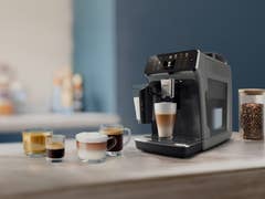Eine Philips Serie 5500 Kaffeemaschine mit verschiedenen Kaffeegetränken auf einer Arbeitsplatte.