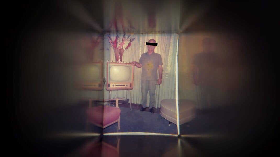 Ein Mann steht neben einem Röhrenfernseher