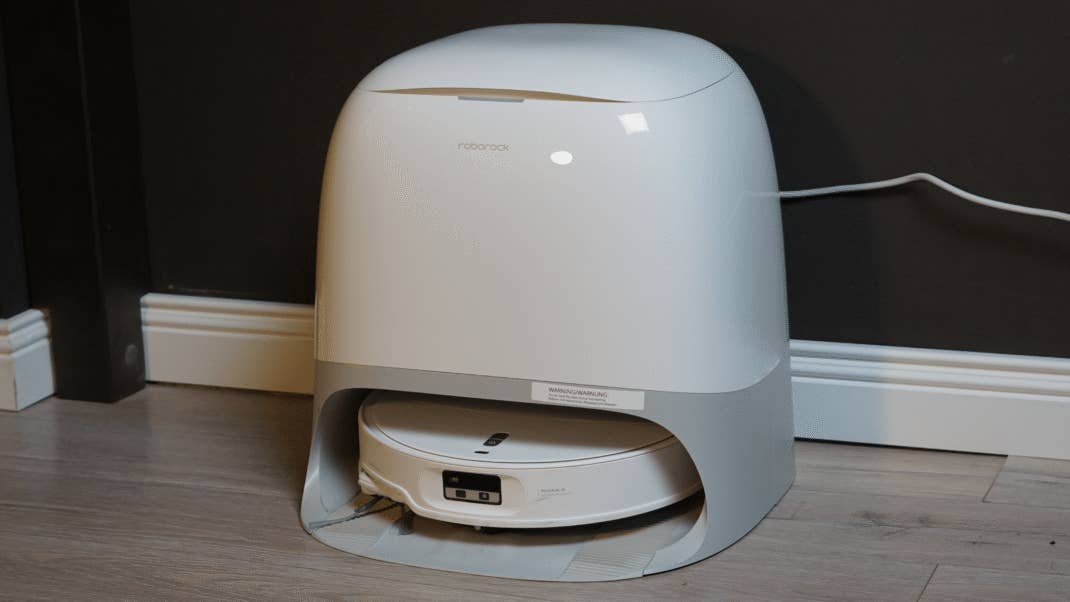 Ein Roborock Qrevo Curv 2 Pro Saugroboter auf einem Holzboden.