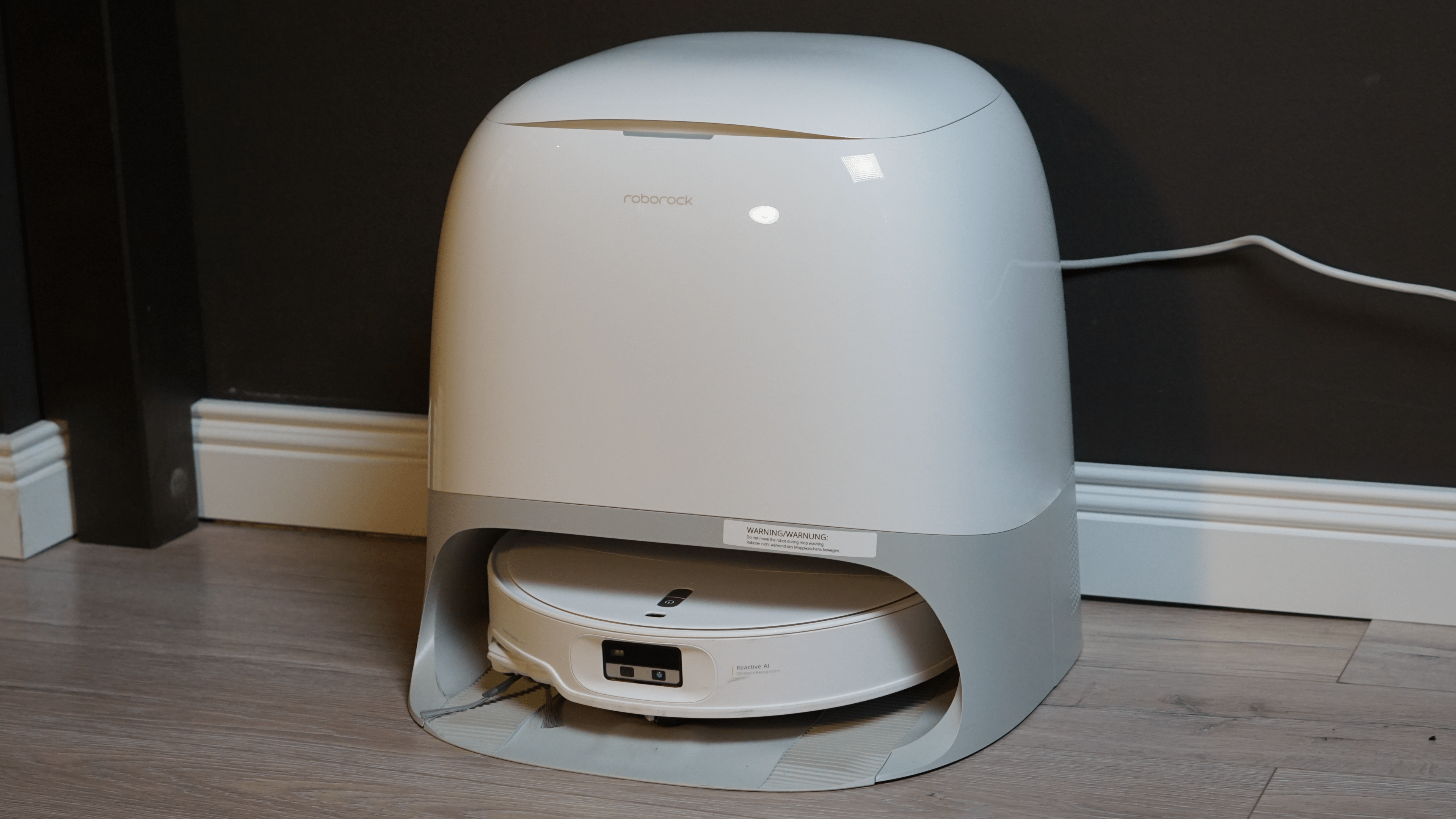 Das ist der Roborock Qrevo Curv 2 Pro Ein Roborock Qrevo Curv 2 Pro Saugroboter auf einem Holzboden.