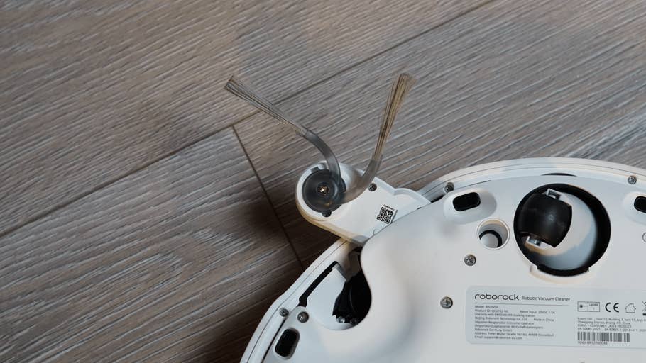 Eine Nahaufnahme des Roborock Qrevo Curv 2 Pro Saugroboters mit Bürsten und Rädern auf der Unterseite.