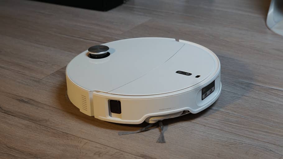 Ein Roborock Qrevo Curv 2 Pro Saugroboter auf Holzfußboden.