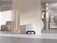 Ein moderner Wohnraum mit einem Roborock Qrevo Curv an einer Wand bei sanfter Beleuchtung.