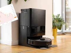 Ein Roborock-Staubsauger, der neben einer Pflanze angedockt ist, mit einem Overlay eines Leistungsdiagramms.