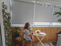 Rollläden mit verschiedenen Schließpositionen in Wintergarten mit Frau im Vordergrund