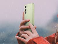 Frau hält das Galaxy A54 im Regen