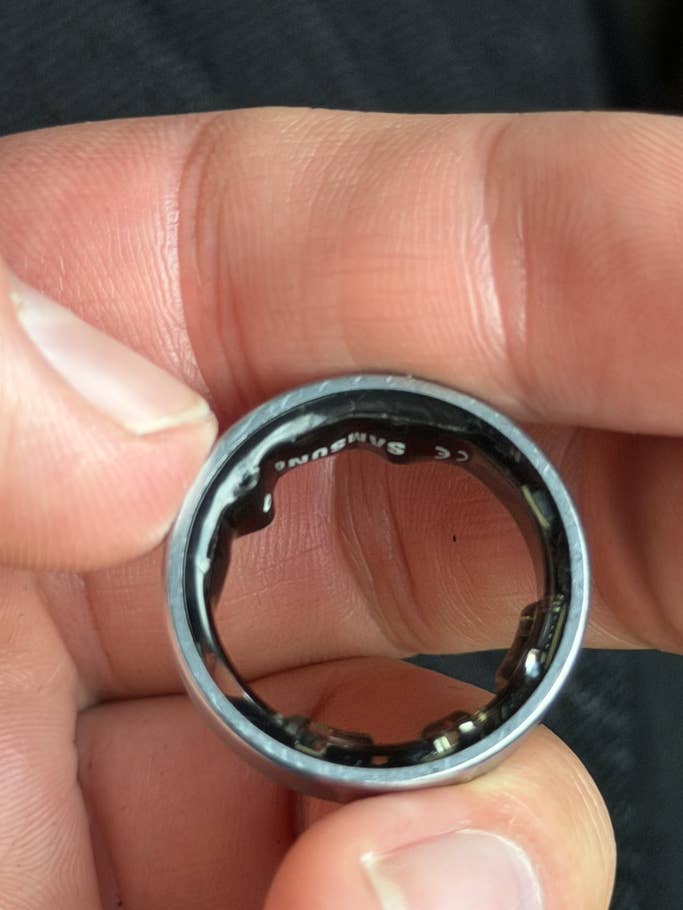 Eine Person hält einen Samsung Galaxy Ring und zeigt die Innenseite mit sichtbaren Markendetails.