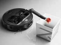Roborock Saros Z70 Staubsauger mit einem Roboterarm, der einen Gegenstand in einen weißen Behälter ablegt.