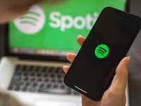 Ein Smartphone, auf dem das Spotify-Logo zu sehen ist.