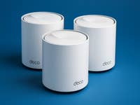 Drei TP-Link Deco X50 Mesh-WLAN-Repeater auf blauem Hintergrund.