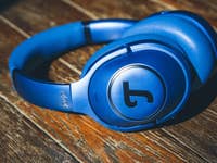 Blaue Teufel Real Blue NC Kopfhörer, die auf einer Holzoberfläche liegen.