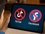 Ein Kind hält ein Tablet mit den Symbolen 'Kein Tik Tok' und 'Kein Facebook'.