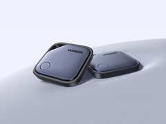 Zwei UGREEN Smart-Tracker auf einer glatten Oberfläche, mit einem Knopf und elegantem Design.