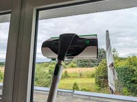 Ein Vorwerk Kobold VG100 Plus Fensterreiniger in Aktion vor einer bewölkten Aussicht.