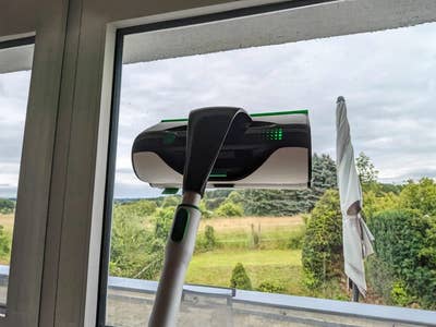 Ein Vorwerk Kobold VG100 Plus Fensterreiniger in Aktion vor einer bewölkten Aussicht.