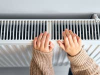 Heizkörper, den Hände auf Wärme überprüfen