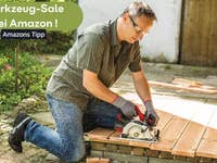 Mann, der in einem Garten auf Holzplanken mit einer Kreissäge arbeitet. Werkzeugverkauf bei Amazon angezeigt.