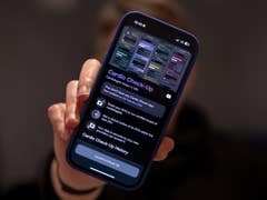 Eine Person hält ein Smartphone, das die Benutzeroberfläche der 'Cardio Check-Up'-App anzeigt.