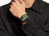 Eine Hand, die eine Xiaomi Redmi Watch 5 trägt, mit gelben und weißen digitalen Zahlen.