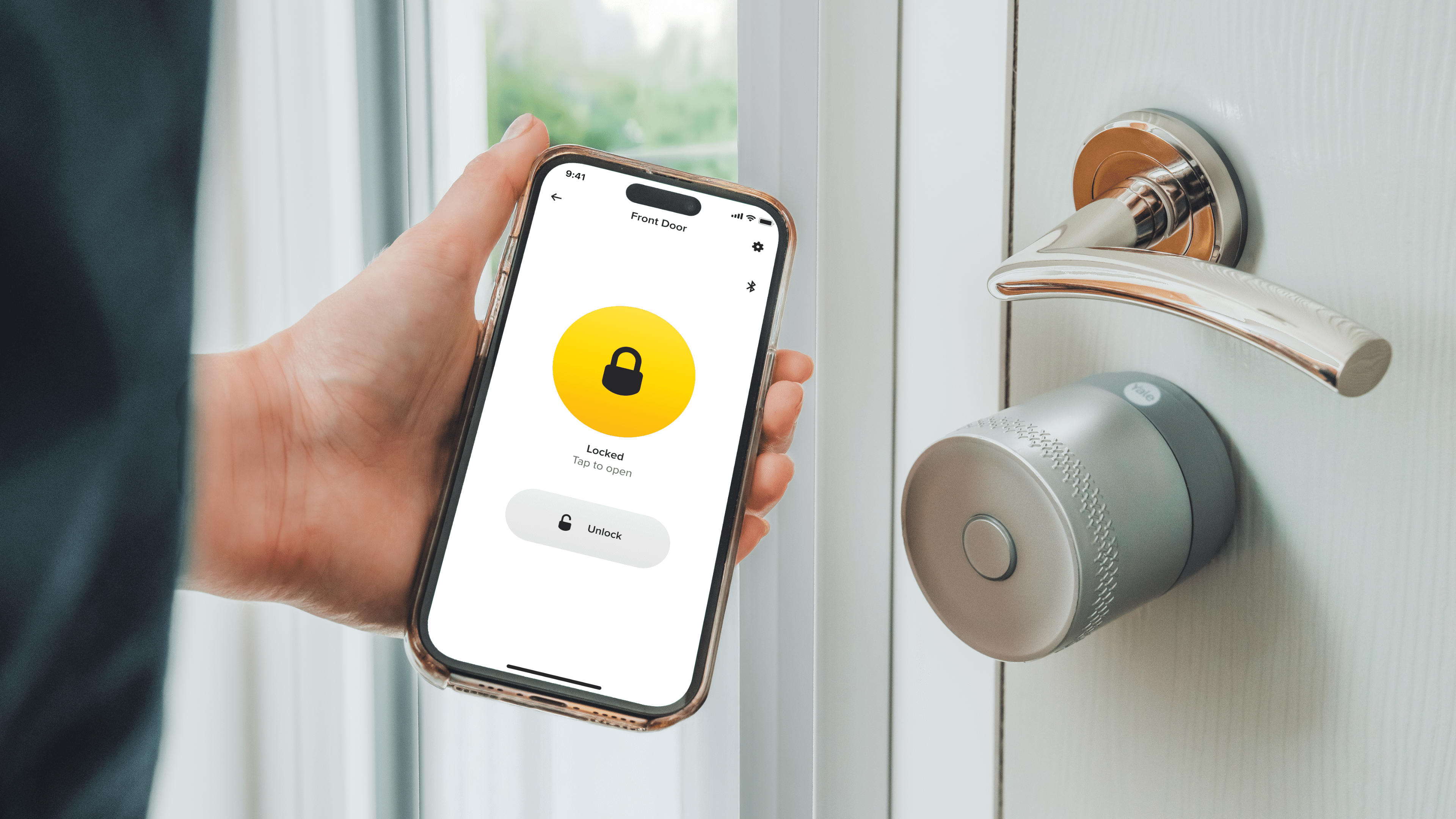 Eine Person hält ein Telefon, das die Yale Linus Smart Lock-App zeigt, die anzeigt, dass es verriegelt ist.