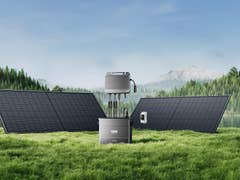 Solarmodule mit einem Solargenerator in einer grünen Landschaft am See und Bergen.