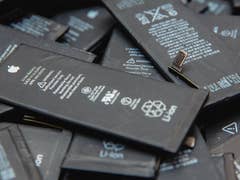 Ein Stapel Lithium-Ionen-Batterien mit Etiketten, die Warnungen und Spezifikationen anzeigen.