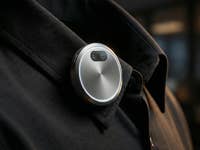 Ein KI-generiertes, rundes KI-Gerät, das an einem Jackenkragen angebracht ist.