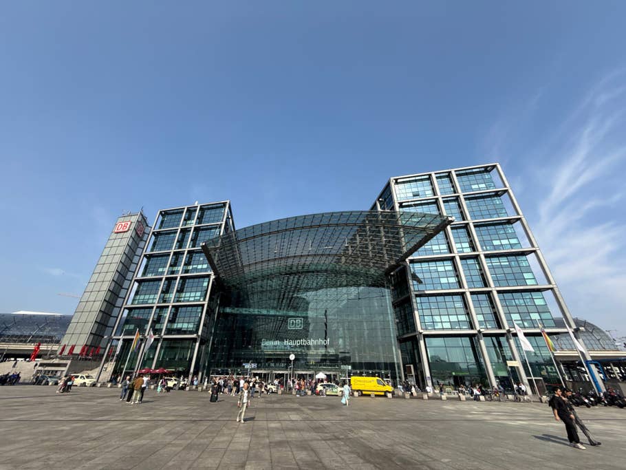 Berlin Hauptbahnhof mit Glasarchitektur und Menschen auf dem Platz.