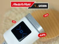 Ein Bosch smartes Heizkörperthermostat II wird mit angeschaltetem Display gezeigt. Darüber das Logo von MediaMarkt/Saturn und daneben Rabatt-Anzeigen.