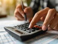 Jemand tippt auf dem Taschenrechner