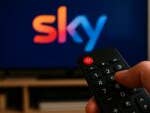 Ein TV mit einem Sky-Logo, im Vordergrund eine Fernbedienung