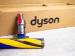 Dyson-Saugbürste vor einem Paket mit Dyson-Schriftzug.