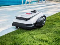 Ecovacs-Mähroboter in einem Garten mit Pool