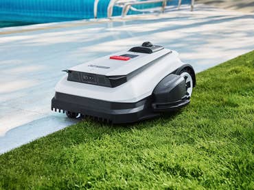 Ecovacs-Mähroboter in einem Garten mit Pool