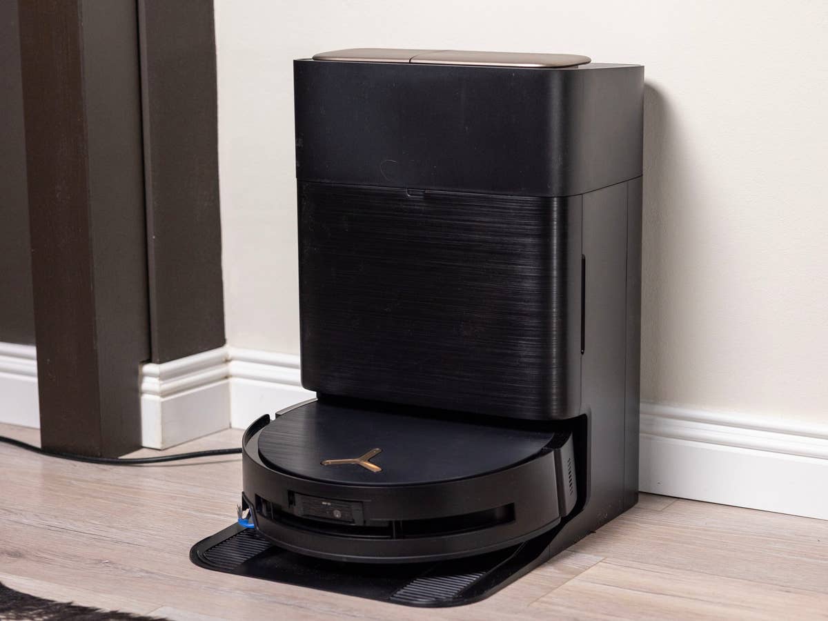 Ecovacs Deebot X9 Pro Omni Ein schwarzer Ecovacs Deebot X9 Pro Omni-Roboterstaubsauger und seine Dockingstation in einem modernen Innenraum.