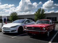 E-Auto neben einem alten Auto mit Verbrennungsmotor.