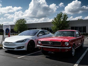 E-Auto neben einem alten Auto mit Verbrennungsmotor.