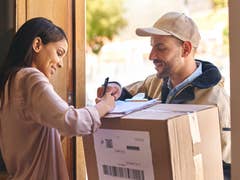 Postbote übergibt Paket an Frau