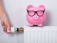 Heizkörper mit Sparschwein Sinnbild für Heizkosten