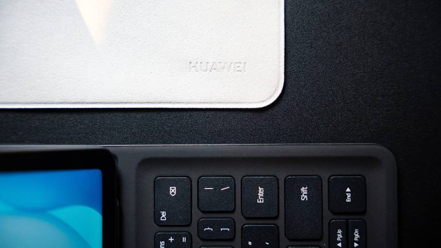 Eine Nahaufnahme einer Huawei-Tastatur und einer weißen, papierähnlichen Matte mit Huawei-Logo.