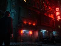 John Wick steht vor einem Laden mit Neonlichtern im Regen.