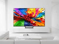 Der Smart-TV LG 75QNED93A6A steht in einem weißen Wohnzimmer.