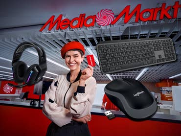 Frau hält eine MediaMarkt-Karte im MediaMarkt-Store. Drumherum Logitech-Geräte