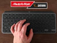 Eine Hand liegt auf einer Logitech MX Keys Mini und darüber sieht man das MediaMarkt/Saturn-Logo