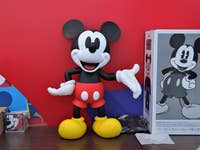 Eine Micky-Maus-Figur vor einem roten Hintergrund.