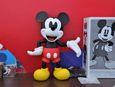 Eine Micky-Maus-Figur vor einem roten Hintergrund.
