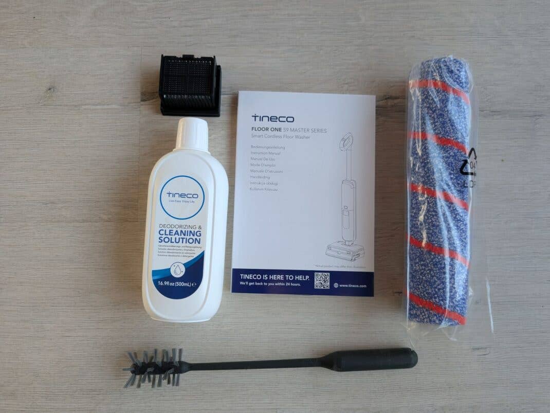 Mit der Bürste reinigt ihr den Saugwischer, außerdem ist noch ein Wechselfilter, eine zweite Bodenbürste und Reinigungslösung dabei