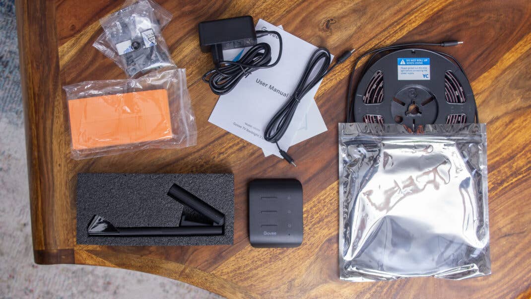 Lieferumfang des Govee TV Backlight 3 Lite auf einem Holztisch ausgebreitet