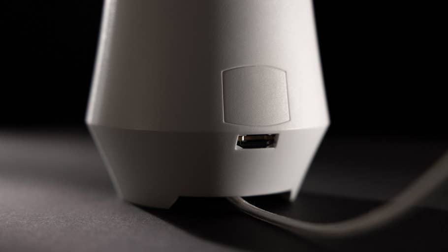 Nahaufnahme eines weißen Luftqualitätsmonitors mit SD-Kartenslot vor dunklem Hintergrund.